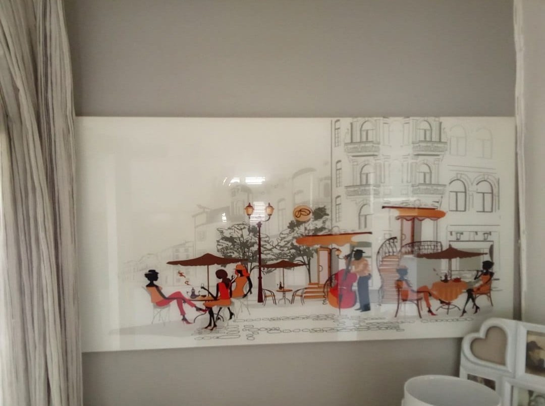 A café scene painted on a glass wall decoration.